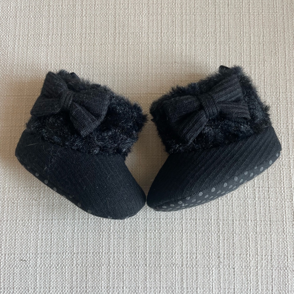 Fuzzy black booties with bows.